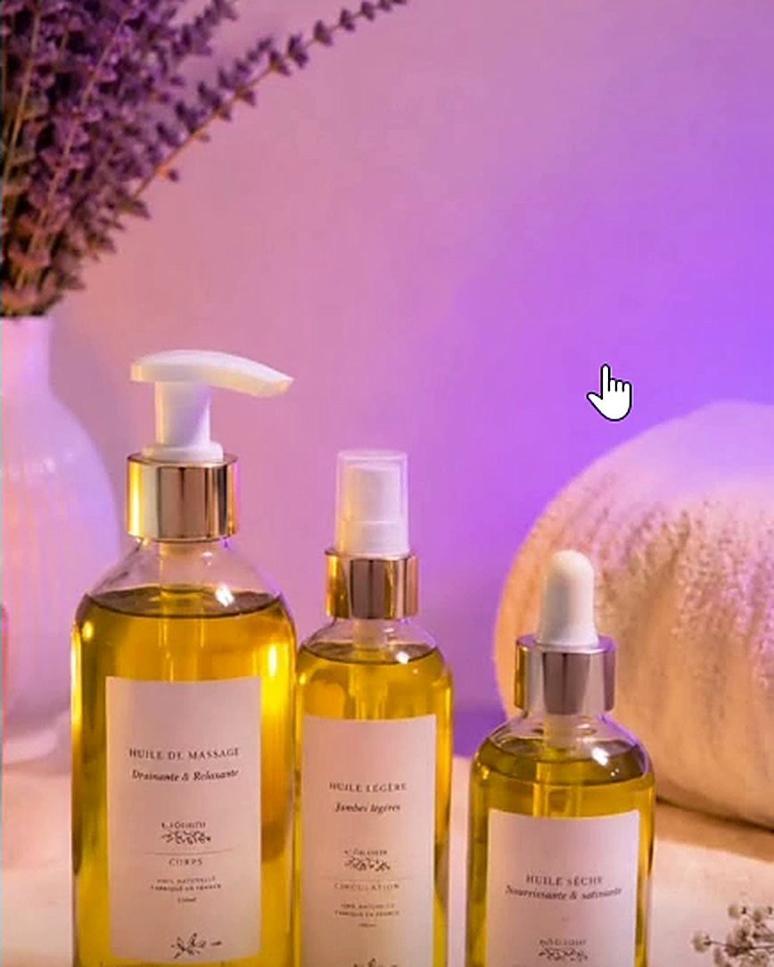 Huiles de massage d'Oasis Féminin sous la lumière mauve du cabinet.